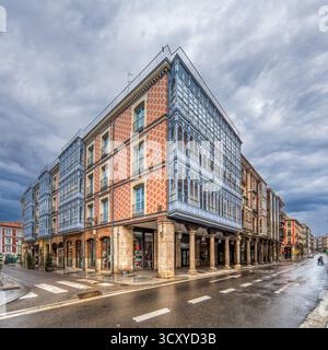 Questo suggestivo edificio d'angolo presenta finestre bovindo in legno blu e mattoni a motivi rossi in Piazza Corrillo, una vista notevole a Valladolid. Foto Stock