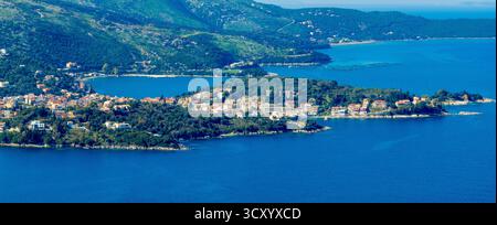 Vista aerea panoramica di Kassiopi, un affascinante villaggio costiero su una lussureggiante penisola verde a Corfù, in Grecia. Una splendida destinazione turistica per il Mar Ionio Foto Stock