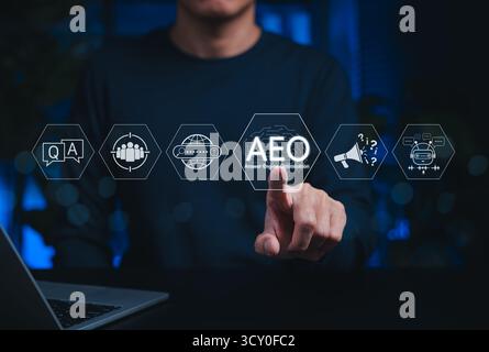 Rispondere al concetto di strategia di ottimizzazione del motore (AEO). La persona interagisce con icone AEO, IA, chatbot, ricerca, domande e Risposte, DOMANDE FREQUENTI, Foto Stock