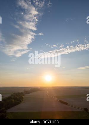 Bergnicourt, Rethel, Ardenne, Grand-Est, Francia, 28 agosto 2025, Un tramonto mozzafiato che illumina l'ampio orizzonte su tranquilli campi adornati da cieli azzurri Foto Stock