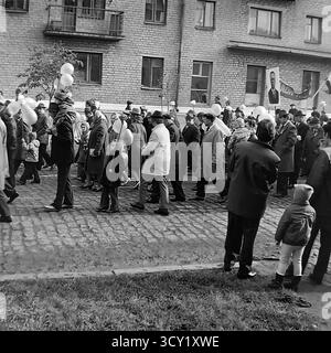 Una suggestiva foto d'archivio del 7 novembre 1974 cattura lo spirito di una parata dell'anniversario della rivoluzione d'ottobre a Sloviansk, RSS Ucraina. Una grande colonna di manifestanti, comprese famiglie con bambini, marcia lungo una strada acciottolata. I partecipanti portano bandiere sovietiche, ritratti di leader politici, striscioni con slogan come "Glory to the Heroes of Labor" e palloncini festivi. Questa immagine è un vivido documento di una grande festa di stato e della vita pubblica di un pacifico Donbas prima della guerra Foto Stock