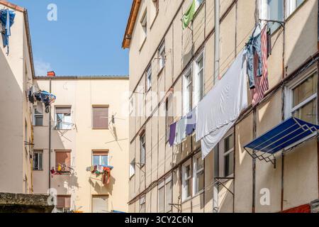 Autentica scena urbana che cattura la vita quotidiana con l'asciugatura della biancheria tra i tradizionali edifici residenziali nel quartiere storico di Vitoria Foto Stock