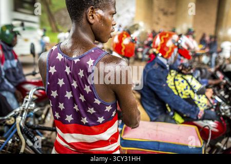 RWA RWANDA RUANDA Kigali taxi autisti con moto e biciclette aspettano sotto un ponte per la fine di un temporale Foto Stock