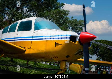 Un'inquadratura accattivante e dall'angolazione ridotta che riproduce la fusoliera anteriore di un classico velivolo monomotore a elica. Il corpo giallo brillante, bianco a contrasto Foto Stock