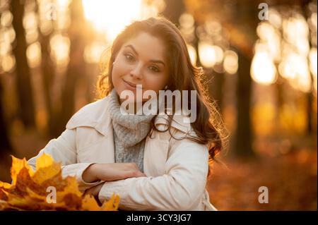 Bella giovane donna che gode di una giornata d'autunno assolata nella natura Foto Stock