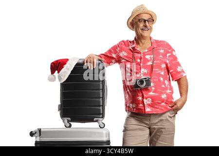 Uomo maturo appoggiato alle valigie, concetto di viaggio natalizio isolato su sfondo bianco Foto Stock