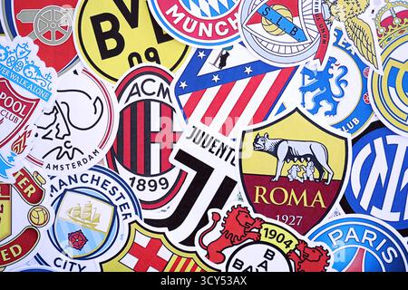 KIEV, UCRAINA - 23 FEBBRAIO 2025 molti emblemi di carta delle squadre di calcio si trovano in grande pila da vicino Foto Stock