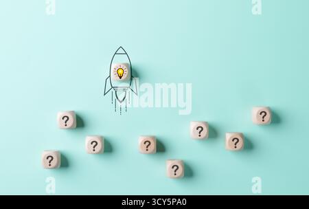 Concetto di risoluzione dei problemi e avvio. Un'immagine concettuale di un razzo con una lampadina che decolla, circondata da cubi con punti interrogativi su una l Foto Stock
