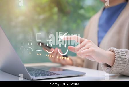 Analisi dei clienti feedback sulla soddisfazione del cliente. La persona interagisce con il laptop, assegnando una valutazione a cinque stelle utilizzando un sistema di feedback digitale, Foto Stock