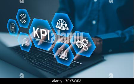 KPI, analisi degli indicatori chiave delle prestazioni. Uomo d'affari che utilizza un notebook per analizzare gli indicatori chiave di prestazione (KPI) visualizzati come icone olografiche, Foto Stock