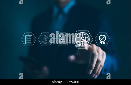 Standard ISO e garanzia di qualità. L'uomo d'affari interagisce con le icone virtuali che rappresentano lo standard ISO, il controllo di qualità, la garanzia, Foto Stock
