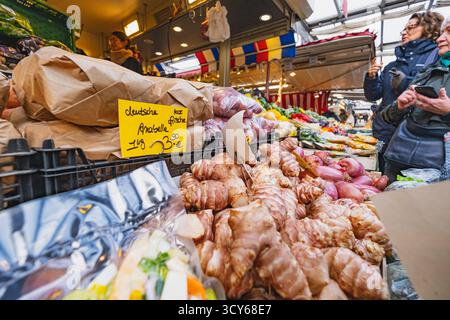 Una vivace banchina del mercato espone verdure fresche, tra cui cipolle, zenzero e patate Foto Stock