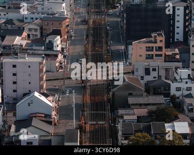 Veduta aerea dall'alto verso il basso del corridoio ferroviario di Osaka attraverso blocchi residenziali Foto Stock