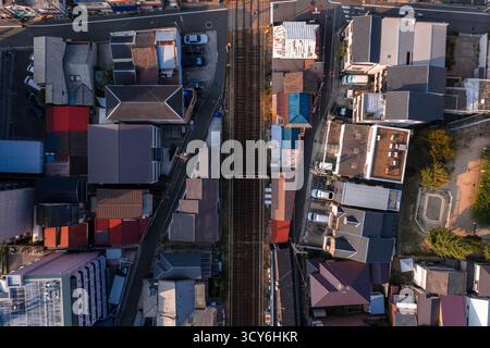Vista aerea dall'alto verso il basso del quartiere di Osaka con binari ferroviari nord-sud Foto Stock
