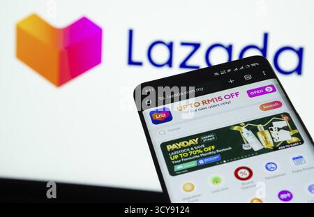 Dhaka, Bangladesh - 03 luglio 2025: Smartphone con interfaccia web Lazada sullo sfondo del logo Lazada Foto Stock