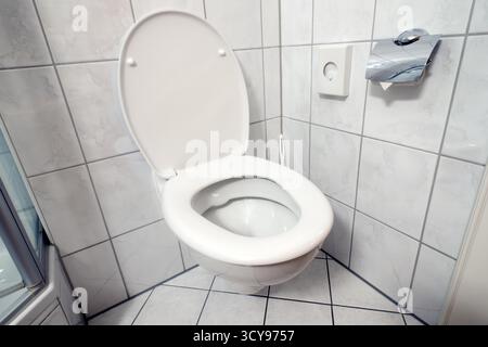 Angolo della toilette pulito con coprisedile aperto Foto Stock