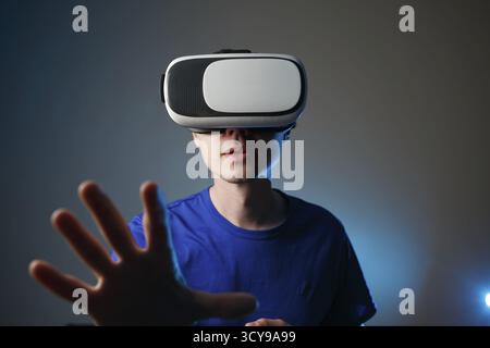 Uomo che indossa occhiali per la realtà virtuale e vuole toccare qualcosa . Il concetto degli occhiali VR Foto Stock