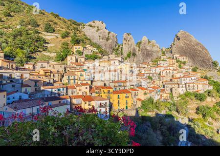 La luce del sole del pomeriggio bagna Castelmezzano, in Italia, mettendo in risalto le case di pietra annidate nelle Dolomiti Lucane. Un cesto di fiori appeso nel Foto Stock