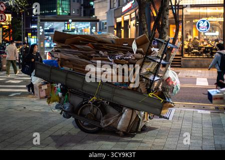 Un carrello per biciclette carico con scatole di cartone in una strada cittadina di notte a Seoul, Corea del Sud, il 20 ottobre 2023 Foto Stock