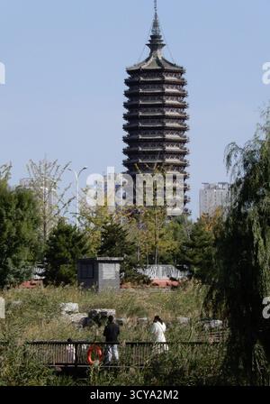 Pechino, Cina. 18 ottobre 2025. Le persone che indossano abiti spessi camminano lungo un canale nel distretto di Tongzhou di Pechino, capitale della Cina, 18 ottobre 2025. Colpita da un'aria fredda forte, Pechino è colpita da un'ondata fredda. Crediti: Li Xin/Xinhua/Alamy Live News Foto Stock