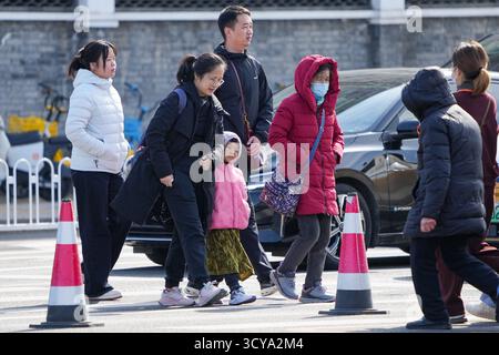 Pechino, Cina. 18 ottobre 2025. Le persone che indossano piumini camminano in una strada di Pechino, capitale della Cina, 18 ottobre 2025. Colpita da un'aria fredda forte, Pechino è colpita da un'ondata fredda. Crediti: Ju Huanzong/Xinhua/Alamy Live News Foto Stock