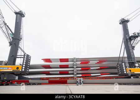 Cuxhaven, Germania - 01.28.2023: Scarico di pale di generatori eolici da una nave da carico mediante due autogru portuali Liebherr. Foto Stock