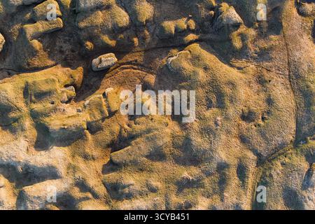 Vista aerea con droni di un paesaggio carsico di pietra calcarea unico in Estonia con antiche formazioni geologiche e una calda luce serale. Foto Stock