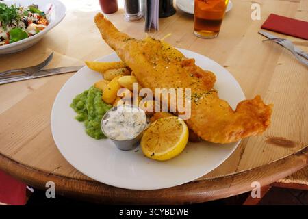 Pesce e patatine tradizionali con piselli di mosca Foto Stock
