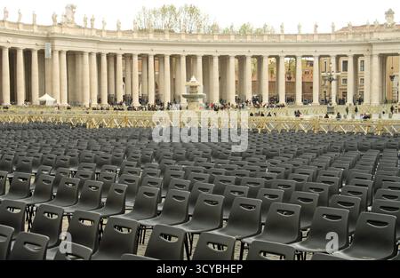 Città del Vaticano: Vista dall'altra parte di Piazza San Pietro fino ai colonnati, mostrando file di sedie vuote disposte per l'udienza papale. Roma, Italia Foto Stock