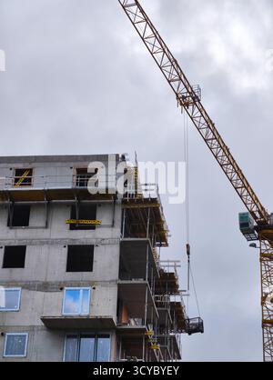 Cantiere con gru a torre e struttura in calcestruzzo parzialmente costruita ad altissima risoluzione per l'uso in ambito architettonico e industriale Foto Stock