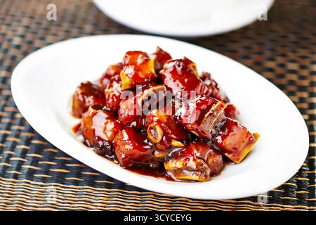 Costolette di maiale dolce e aspro servite nel piatto con vista laterale dell'antipasto Braised Asian Cuisine Foto Stock