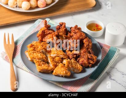 Cosce di pollo, filetto di gamberi e palline di riso fritte con salsa servite in piatto con forchetta isolata sul tovagliolo vista laterale del cibo di taiwan Foto Stock