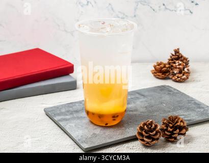 Bevanda gassata al limone Passion servita in vetro usa e getta isolato a bordo con vista laterale della bevanda ghiacciata taiwanese Foto Stock