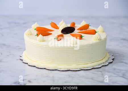 Torta di carote decorata, con strati di torta umidi e speziati ricoperti da una crema di formaggio liscio e una vista laterale della deliziosa torta Foto Stock