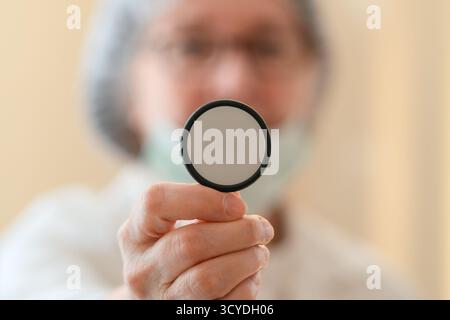 Medico donna in cappotto bianco e maschera medica che tiene il diaframma stetoscopio per l'esame polmonare. Concentrarsi sulla diagnosi di malattie respiratorie, polmonite, bronchite e trattamento. Foto Stock