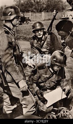 I soldati tedeschi della Wehrmacht gestiscono una radio da campo durante la seconda guerra mondiale. Gli uomini, indossando stadilhelm standard e uniformi del primo conflitto, coordinano le linee di comunicazione in un ambiente rurale accanto al veicolo militare. Circa foto dei primi anni '1940. fotografo non identificato Foto Stock