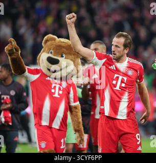 Monaco, Germania. 18 ottobre 2025. Harry Kane (R) del Bayern Monaco festeggia con la mascotte del club "Berni" dopo la partita di calcio tedesca di prima divisione tra Bayern Monaco e Borussia Dortmund a Monaco, Germania, 18 ottobre 2025. Crediti: Philippe Ruiz/Xinhua/Alamy Live News Foto Stock