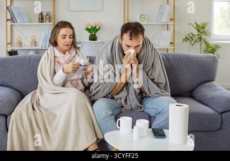 Coppia malata che soffre di febbre e naso che cola, raffreddore e sintomi influenzali a casa Foto Stock