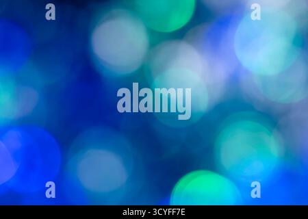 Bokeh blu, verde e bianco: Sfondo astratto delle vacanze con luci sfocate della ghirlanda natalizia Foto Stock