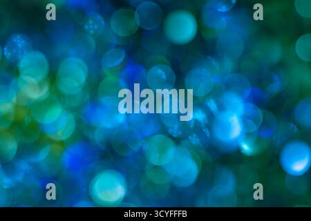 Bokeh blu, verde e bianco: Sfondo astratto delle vacanze con luci sfocate della ghirlanda natalizia Foto Stock
