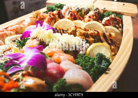 Vista ravvicinata di un sushi boat, caratterizzato da una varietà di pezzi di sushi. Foto Stock
