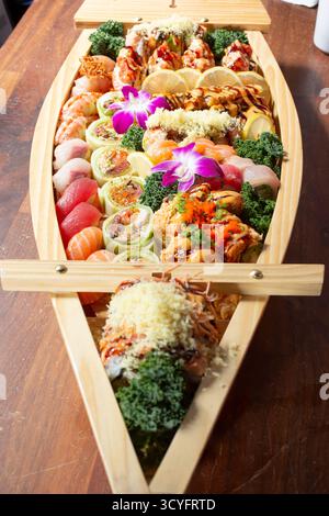 Vista su una barca sushi, con una varietà di pezzi di sushi. Foto Stock