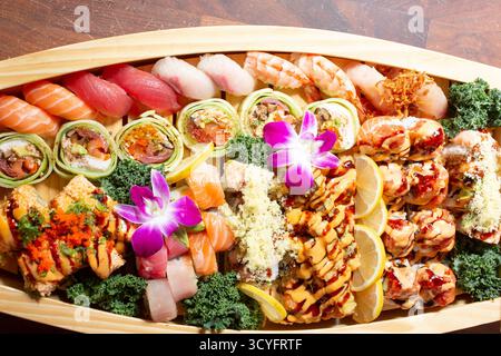 Una vista dall'alto verso il basso di un sushi boat, caratterizzato da una varietà di pezzi di sushi. Foto Stock
