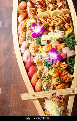 Una vista dall'alto verso il basso di un sushi boat, caratterizzato da una varietà di pezzi di sushi. Foto Stock