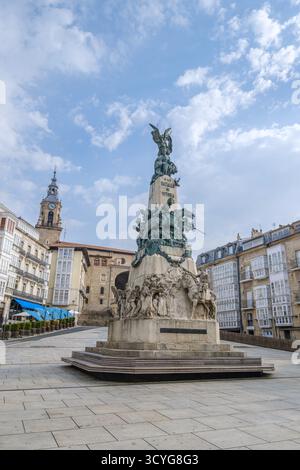 Monumento alla Battaglia di Vitoria (1813) in Piazza Virgen Blanca, Vitoria Gasteiz, Spagna, con Torre dell'Orologio ed edifici storici Foto Stock