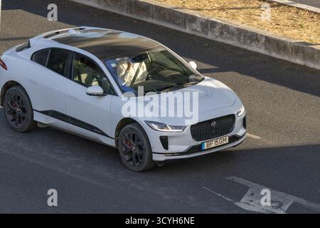Auto elettrica bianca jaguar i pace in movimento su strada durante il giorno Foto Stock