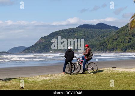 Ciclisti sulla spiaggia di Peruibe, Brasile Foto Stock