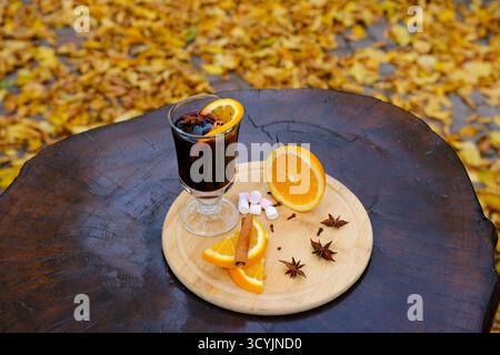 VIN brulé con cannella, spezie e arancia su sfondo chiaro, bevanda tradizionale per le vacanze invernali. Foto di alta qualità Foto Stock