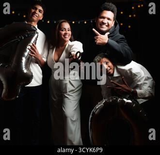 giovane donna che festeggia il suo 40 ° compleanno con la famiglia, sono vestite di donna nera e oncia che festeggia il suo 40 ° compleanno con la sua famiglia, loro ar Foto Stock