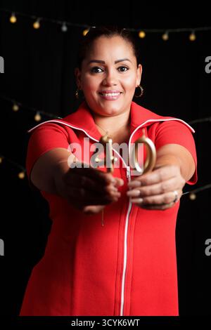 Una donna con un vestito rosso che tiene due candele, una delle quali è etichettata 40. Sta sorridendo Foto Stock